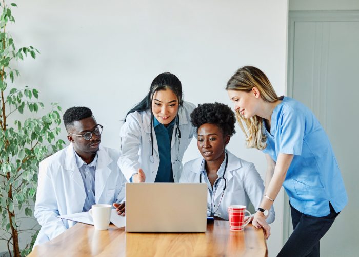 portrait of a doctors and nurses with laptop sitting by desk on their office